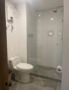 een badkamer met een toilet en een glazen douche bij Luxury Loft Avenida Santander in Manizales