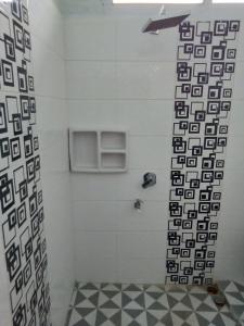 bagno con doccia e piastrelle bianche e nere di Ratu Balqis Homestay a Banda Aceh