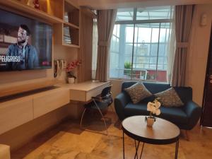 a living room with a tv and a couch and a table at Chanka Suites in Talavera