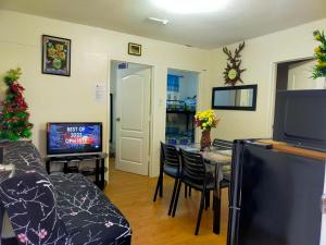 a living room with a dining room table and a television at Two-Bedroom at San Remo Oasis in Cebu City