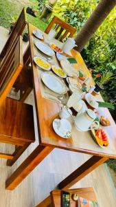 una mesa de madera con platos y utensilios. en Green Mountain Villa, en Ella