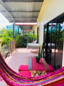 een hangmat op een patio met een tafel en een bank bij Casa Ula, en el corazón de Uvita in Uvita