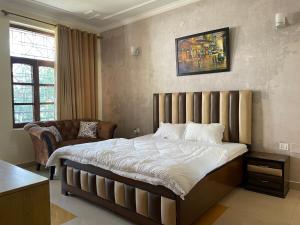 1 dormitorio con 1 cama grande y 1 silla en Aarohan Cottage By Ganga Kripa en Rishīkesh