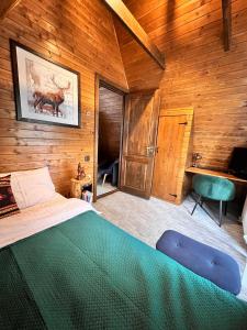a bedroom with a large bed and a sink at Chalet A Baisoara - Cabana A-Frame la munte in Băişoara