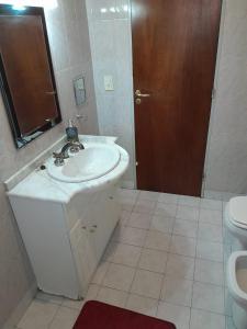 a bathroom with a sink and a toilet at Departamento La Plaza in La Falda +26 photos