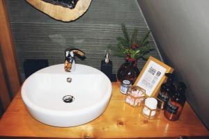 a white sink on a wooden counter in a bathroom at Chalet A Baisoara - Cabana A-Frame la munte in Băişoara