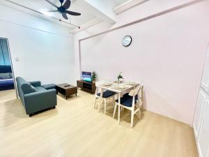 a living room with a table and a couch and a clock at G7 1-8Pax Sunway Medical Center 2Room Geo Avenue in Kampong Penaga