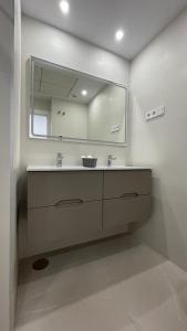 een badkamer met een wastafel en een grote spiegel bij Sea View Mountain Duplex near Benidorm in Finestrat