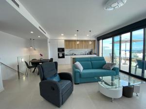 een woonkamer met een blauwe bank en een tafel bij Sea View Mountain Duplex near Benidorm in Finestrat