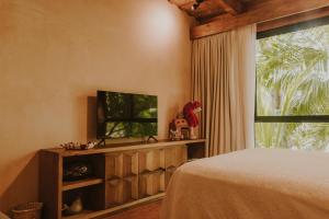 a bedroom with a bed and a tv and a window at Las Haditas in Chiapa de Corzo