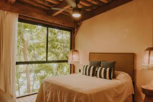 1 dormitorio con cama y ventana grande en Las Haditas, en Chiapa de Corzo