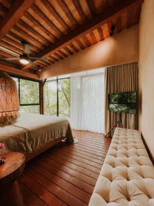 a bedroom with a bed and a flat screen tv at Las Haditas in Chiapa de Corzo