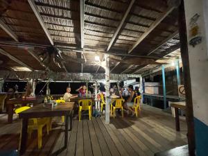 een groep mensen die aan tafel zitten in een restaurant bij Beach Shack Chalet - Garden View Aframe Small Unit in Tioman Island