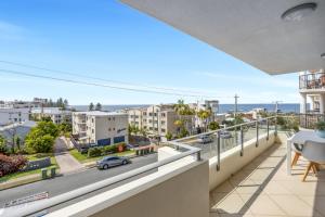 a balcony with a view of a street at Beachside Stunning 3-Bed with Ocean View & Pool in Caloundra