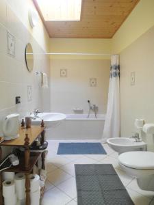 a bathroom with a tub and a sink and a toilet at Gästezimmer Casa Lundo 52 in Comano