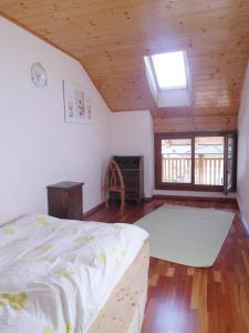 a bedroom with a bed and a wooden ceiling at Gästezimmer Casa Lundo 52 in Comano