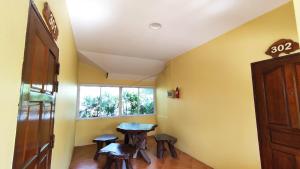 Habitación con mesa, taburetes y ventana en The Grand Jamjuree Resort Lamphun 