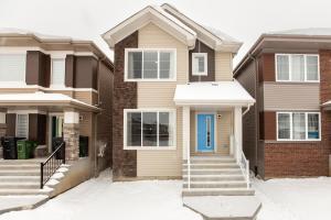 a house with a blue door in the snow at Single detached house with 3 BRM in Edmonton