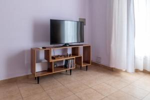 a flat screen tv on a stand in a room at Casa Sol Colonial in San Martín