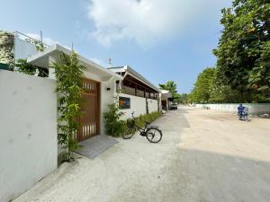 una bicicleta estacionada al lado de un edificio al lado de una casa en ONE SEASON THODDOO, en Thoddoo