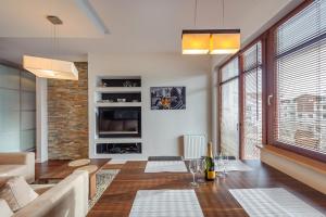 a living room with a couch and a table at Beach Point Apartment - Neptun Park in Gdańsk