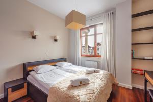 a bedroom with a bed with two towels on it at Beach Point Apartment - Neptun Park in Gdańsk