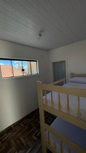 - une chambre avec un lit et une fenêtre dans l'établissement Pousada Três Marias Cachoeira Paulista, à Cachoeira Paulista