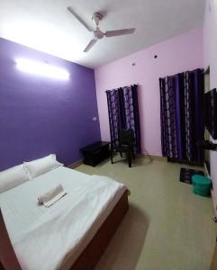 een slaapkamer met een groot bed en een plafondventilator bij Aryan guest house in Bodh Gaya