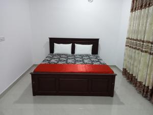 1 dormitorio con 1 cama con colcha roja en Nature View en Batticaloa