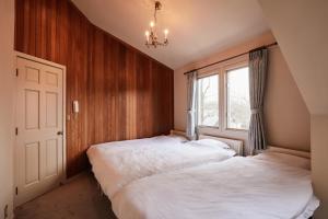 a bedroom with two beds and a window at -AngelTree- 正統派アメリカンスタイルの温泉付き広々別荘 in Nasu-yumoto