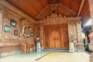 een kamer met een houten deur met stoelen en een tafel bij Homestay Jro Mangku Gede House in Penginyahan