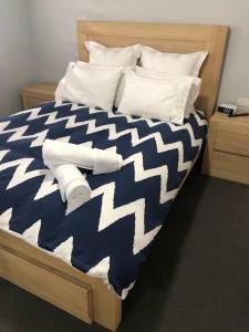 a bed with a blue and white comforter and pillows at Best Value With City View Sleeps 7 in Brisbane