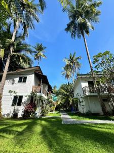 a house with palm trees in front of it at Eagleye Langkawi in Tanjung Rhu 