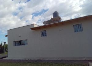 een wit gebouw met ramen en een dak met een opening bij La venecia in Guaymallen