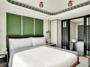 um quarto com uma cama branca e paredes verdes em InterContinental Chiang Mai The Mae Ping, an IHG Hotel em Chiang Mai