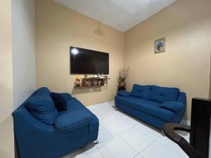 ein Wohnzimmer mit 2 blauen Sofas und einem Flachbild-TV in der Unterkunft La Casa del Zoomat in Tuxtla Gutiérrez