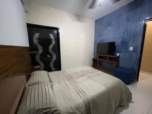 ein Schlafzimmer mit einem großen Bett und einem TV in der Unterkunft La Casa del Zoomat in Tuxtla Gutiérrez