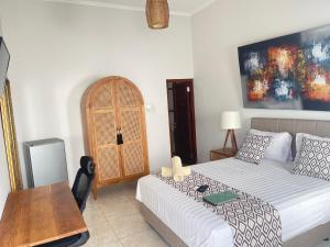 Sala de estar con cama y mesa en Canggu - Pererenan Guesthouse " aBaliHouse ", en Canggu
