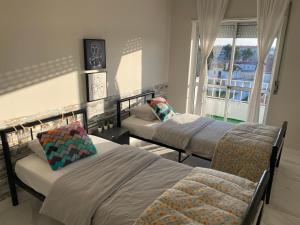 a bedroom with two beds and a chair and a window at Elegance to close from Lisbon! in Montijo