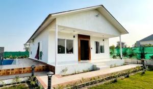 a small white house with a large window at Banke bihari farm in Noida