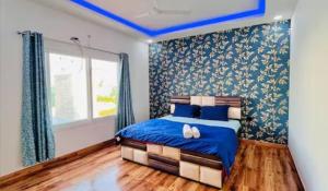 a bedroom with a bed with blue sheets and a window at Banke bihari farm in Noida