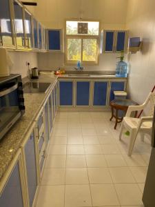 een keuken met blauwe kasten en een tafel bij the beach house in Al Marfaʼ