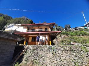 three people standing on the roof of a house at Hiker's Homestay in Banaue +16 photos