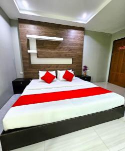 a bedroom with a large bed with red pillows at The JRJF Hotel near Tagum Terminal in Tagum