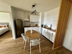 uma cozinha com mesa e cadeiras num quarto em Bel appartement vue mer - Mafat'appart em La Possession