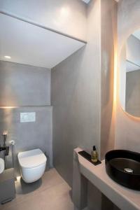 a bathroom with a white toilet and a sink at Villa Mirage - Super Paradise beach in Mýkonos City