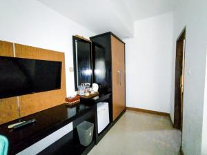 una habitación de hotel con una gran TV y una habitación en Green Hayaq Hotel, en Selong