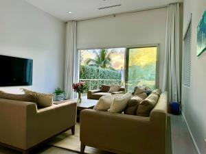 a living room with two couches and a large window at Villa Olea in George Town