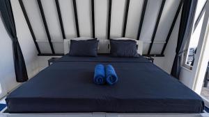 Zwei blaue Hausschuhe liegen auf einem Bett in der Unterkunft Beach Resort Gili Trawangan in Gili Trawangan