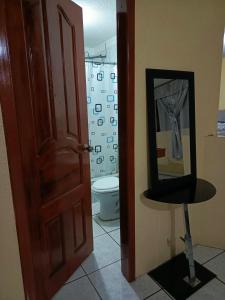 a bathroom with a toilet and a mirror at Casa relax in Quito